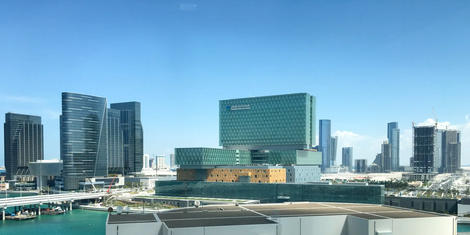 The green glass buildings of Cleveland Clinic Abu Dhabi among towers on Al Maryah Island