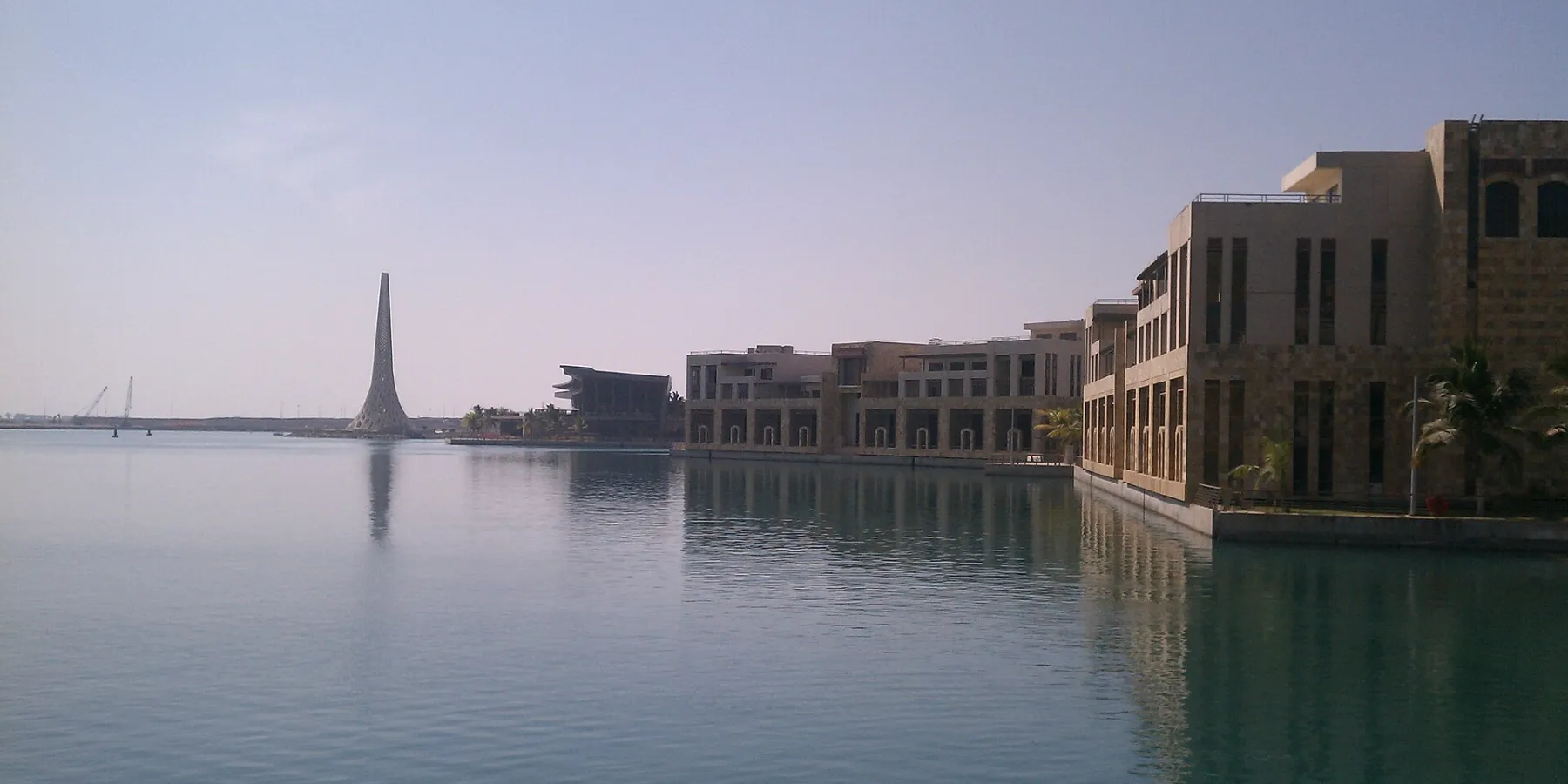 KAUST campus buildings and the university beacon reflected in the harbour at Thuwal