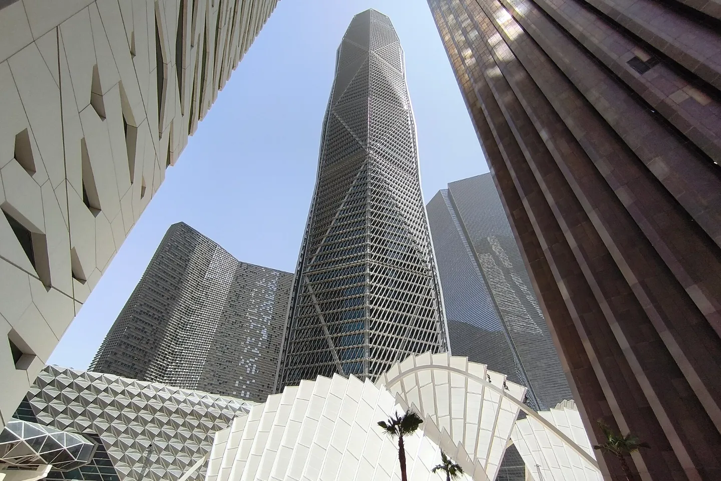 The faceted Public Investment Fund tower seen from street level between buildings in King Abdullah Financial District